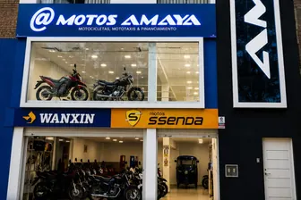 Fachada de la tienda de Motos Amaya en Piura: rótulo azul, vitrinas con motos y los letreros de Wanxin y Ssenda